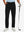 Lightweight moisture wicking dress pants in black, front lower-body with model leaning on golf club.