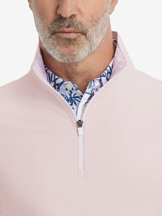 Close-up from nose to chest, showing collar and zipper detail of the light pink golf pullover.