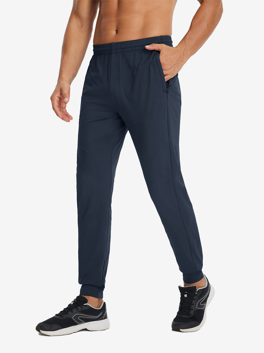 Side view of model with hand in pocket wearing lightweight traning track pants in navy.