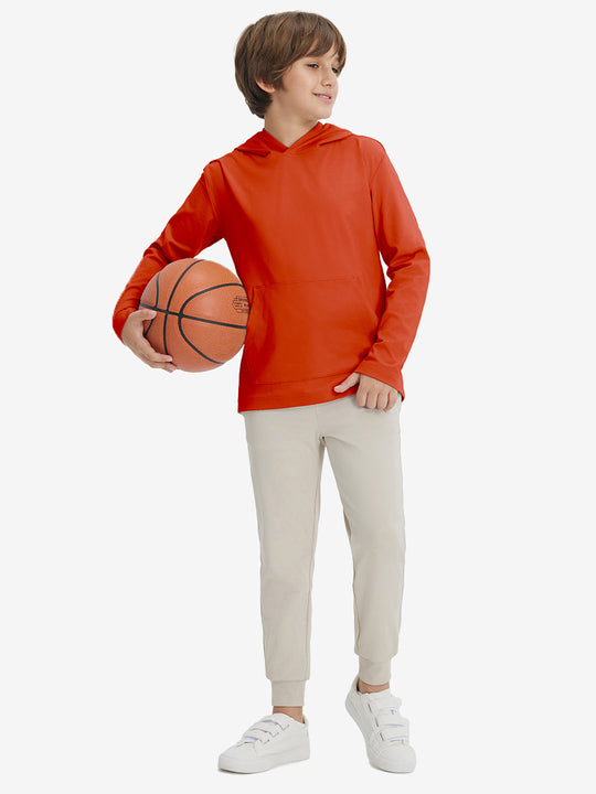 Full-body view of model holding basketball, wearing youth long sleeve hoodied with kangaroo pocket in orange.