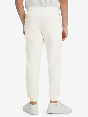 Model's lower body from the back, wearing beige fleece stretch water resistant boys joggers.