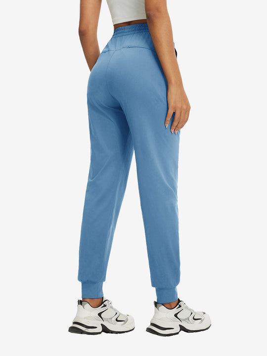 Back view of lightweight women's stretchy joggers sweatpants on model, shown in misty blue.