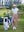 Model on course holding club and bag in Women's 7/8 ankle golf track pants, pink