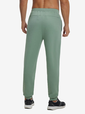 Back lower body view showing beryl green soft sweatpants with 4 zipper pockets