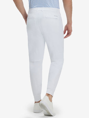 Back lower body shot of model wearing white flat front golf joggers pants with belt loops
