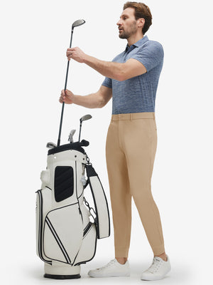 Front full body shot of model wearing light khaki flat front golf joggers pants with belt loops