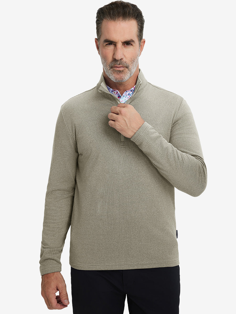 Model grabbing half-zip collar, wearing casual fleece lined quarter zip pullover in dust beige.