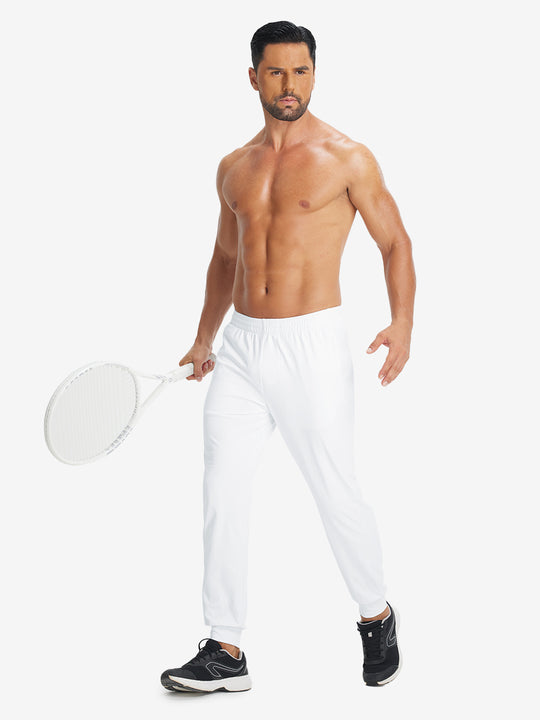 Model holding tennis racket wearing lightweight traning track pants in white.