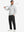 Full-body shot of model holding a golf club while wearing black thermal water repellent fleece dress pants