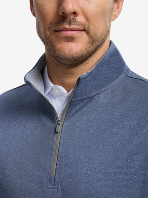 Front shot from nose to chest of model wearing colony blue melange lightweight sleeveless quarter zip golf vest