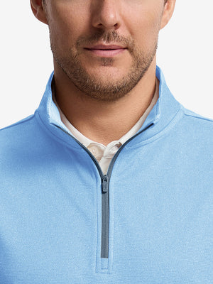 Front shot from nose to chest of model wearing light blue melange lightweight sleeveless quarter zip golf vest