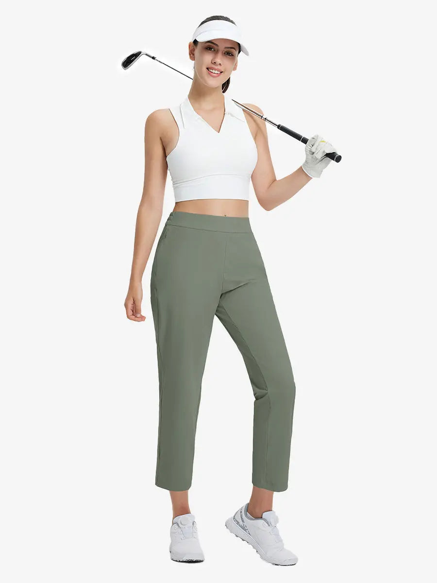 Full-body front view wearing golf hat and holding club in OLIVE GREEN Women's 7/8 Ankle Golf Track Pants.