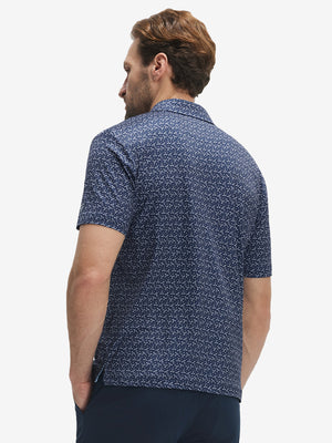 Back half-body view of model wearing the dark blue golf club 4 way stretch print collared polo shirt, highlighting the rear silhouette