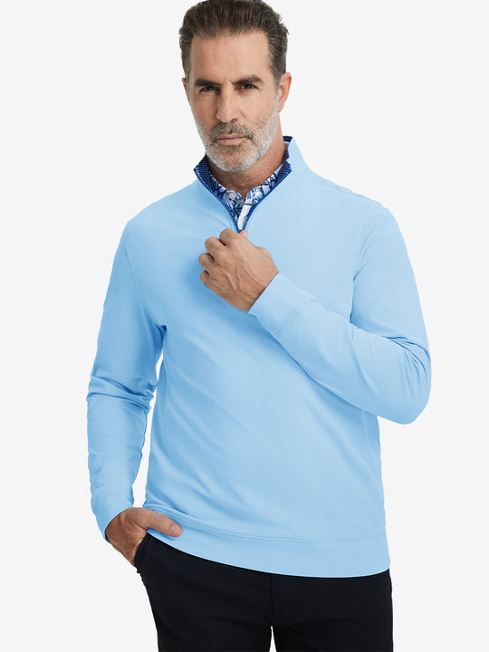 Front upper body view of model wearing lightweight golf quarter zip pullover in light blue, relaxed fit.