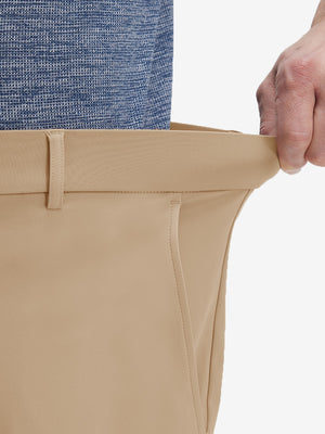 Detail view of elastic waistband on light khaki flat front golf joggers pants with belt loops