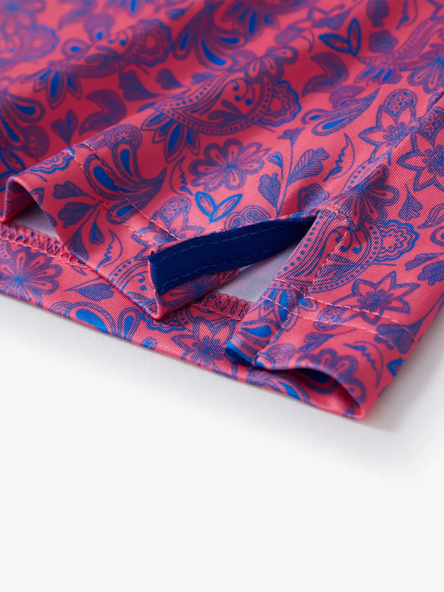 Detail view of the coral paisley pattern polo shirt, focusing on the elegant hem opening and stylish stitching.