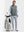 Front full body shot of model wearing grey melange lightweight sleeveless quarter zip golf vest with one hand resting on golf bag