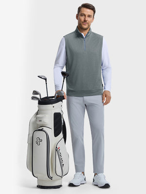 Front full body shot of model wearing grey melange lightweight sleeveless quarter zip golf vest with one hand resting on golf bag