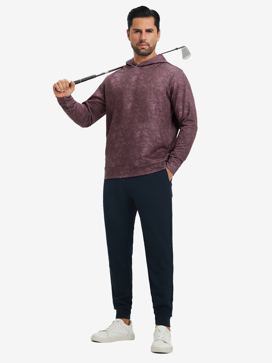 Full-body view of model in purple red exclusive print kangaroo hoodies holding a golf club outdoors.