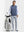 Front full body shot of model wearing colony blue melange lightweight sleeveless quarter zip golf vest with one hand resting on golf bag
