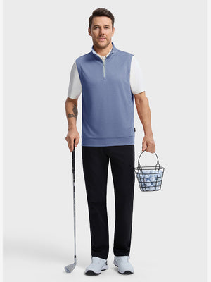 Front full body shot of model wearing navy melange lightweight sleeveless quarter zip golf vest, holding a golf club in one hand and carrying a basket of golf balls in the other hand