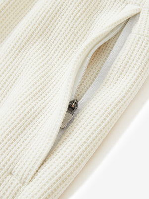 Detail of zipper pocket on soft sweatpants with 4 zipper pockets in beige