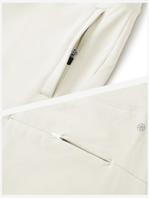 Detailed view of the front side pocket on women's stretch fleece lined water resistant joggers in beige, showing stitching and design.