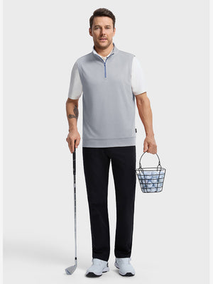 Front full body shot of model wearing lunar rock melange lightweight sleeveless quarter zip golf vest, holding a golf club in one hand and carrying a basket of golf balls in the other hand
