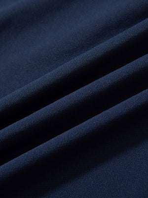 Close-up of navy ventilated pique performance polo fabric texture.