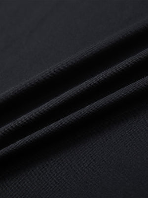 Close-up of black ventilated pique performance polo fabric texture.
