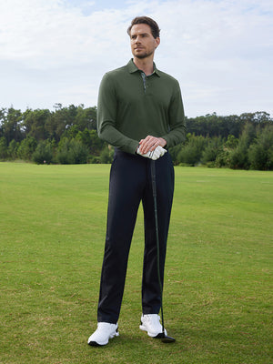 Model in olive green long sleeve solid jersey polo holding a golf club outdoors, full-body shot