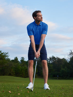 Model in cobalt your favorite jacquard polo preparing to tee off, full-body shot