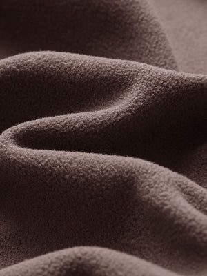 Close-up fabric detail of golf fleece winter puffer jackets, quilted texture and warm feel in dark brown