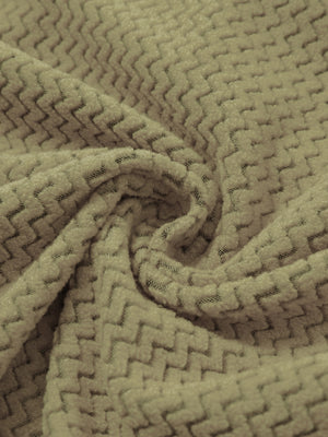 Fabric close-up of warm stretchy quarter zip with pocket, smooth knit texture and flexible feel in forest desert yellow